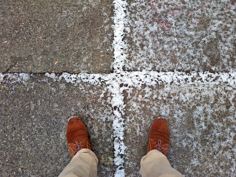 脚踩在雪地里的瓷砖上。