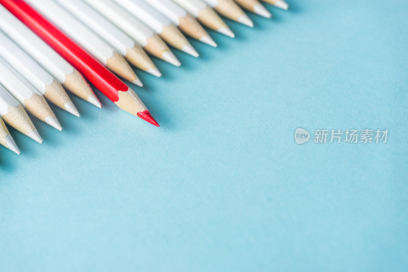 许多白色铅笔和彩色铅笔在蓝色纸的背景。