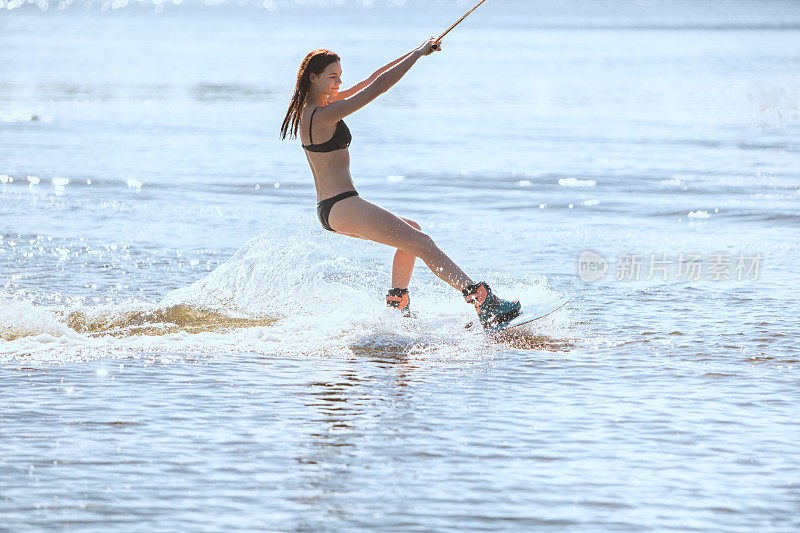 穿泳衣的女人喜欢水上滑板。