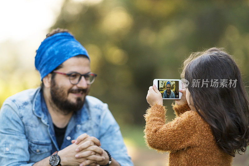 父亲和女儿用手机拍照