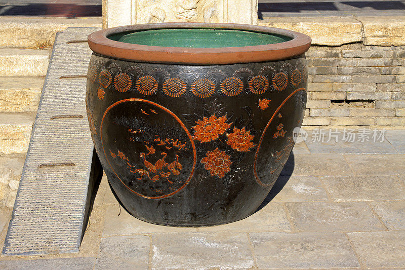 在一座寺庙的陶瓷水缸上雕刻图案，特写照片