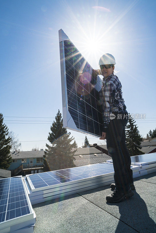 女建筑工人正在安装太阳能电池板