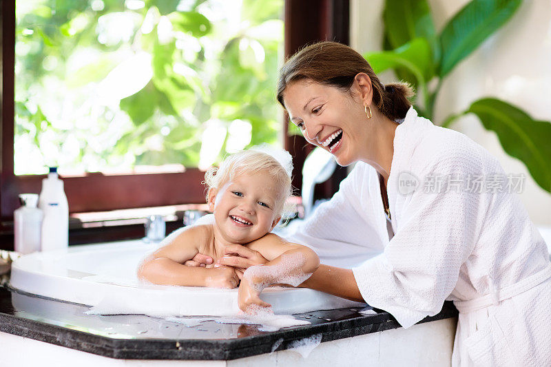 妈妈用泡泡浴给婴儿洗澡。水的乐趣。