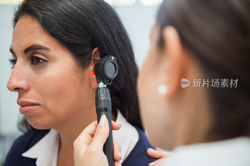 医生用耳镜检查妇女的耳朵