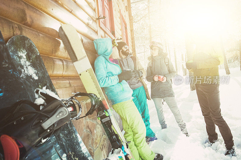 四个朋友在雪山小屋前喝茶