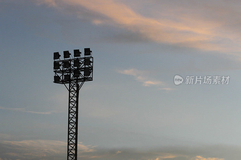 聚光灯在体育场与橙色的天空。
