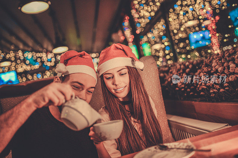 可爱情侣在咖啡厅餐厅喝茶，共度除夕