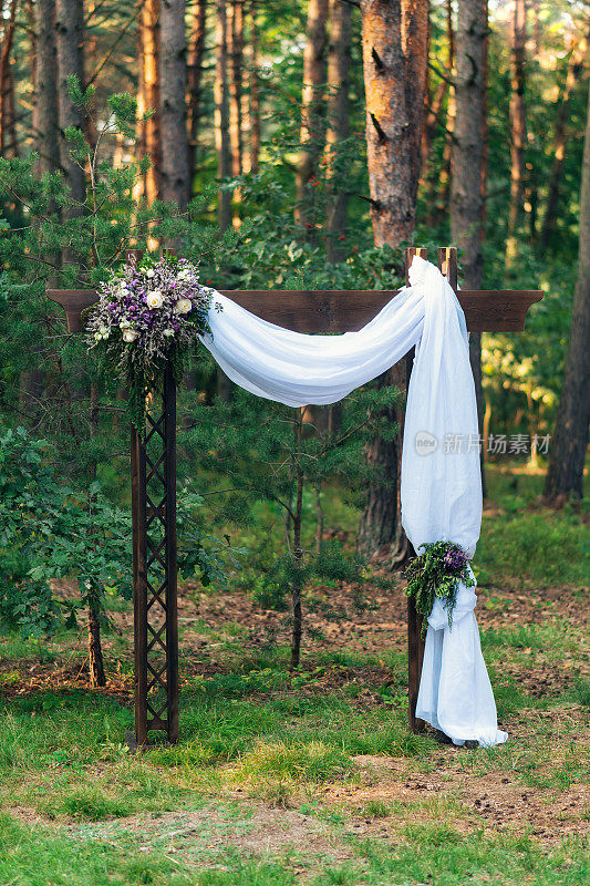 婚礼拱门装饰的鲜花户外。漂亮的婚礼布置。夏天的现代婚礼