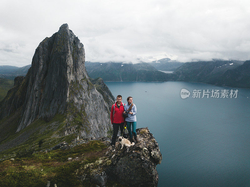 挪威北部山顶上的女人、男人和狗的航拍照片