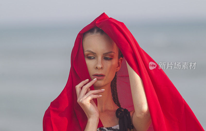 年轻的俄罗斯女子与披肩在土耳其伊斯坦布尔西里夫里海滩摆姿势