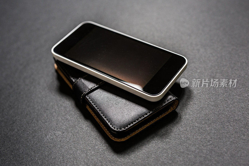 黑色背景上的智能手机和钱包