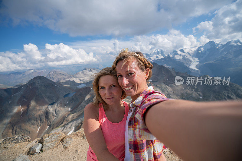 两个女孩在山顶远足时拍自拍照