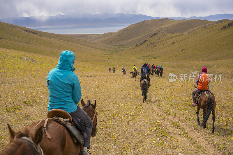 一大群骑马旅游的游客前往吉尔吉斯斯坦的松科尔湖