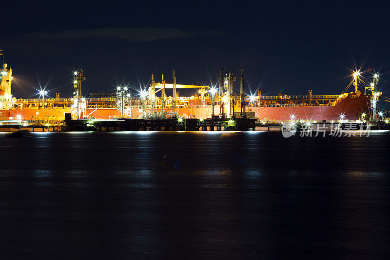 海湾夜晚与油船在炼油厂港口，背景与拷贝空间