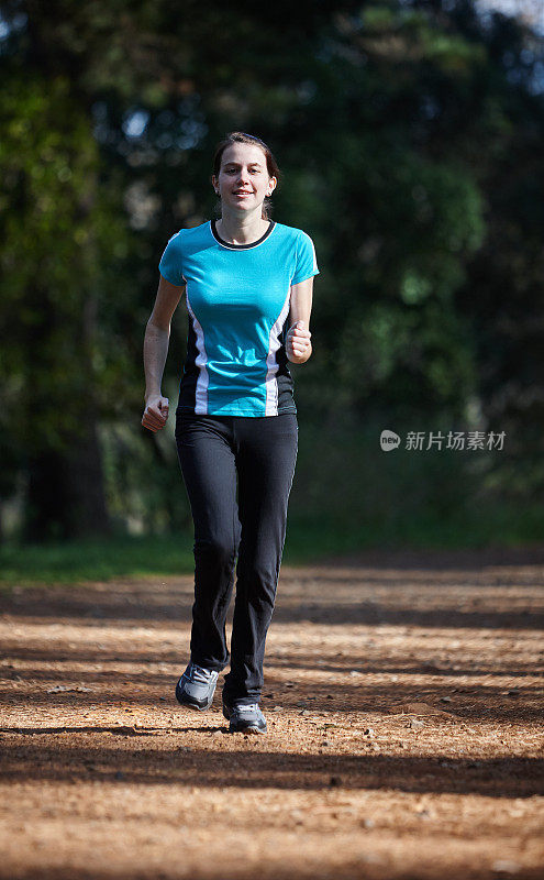 美丽的年轻女子在森林里奔跑以保持健康