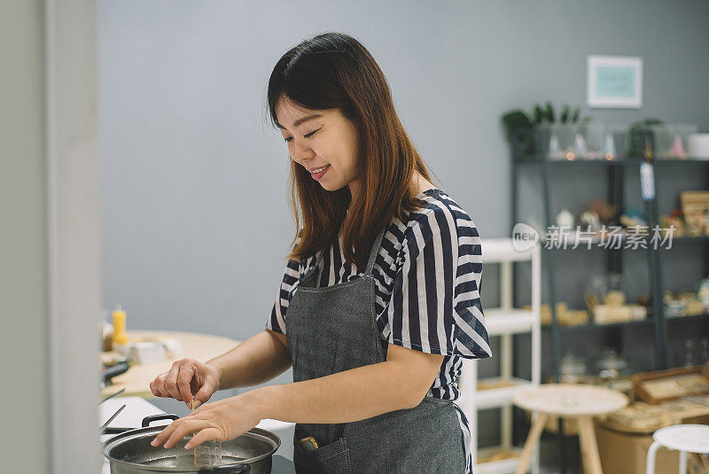 一个亚洲的中国女人在煮大豆蜡混合物