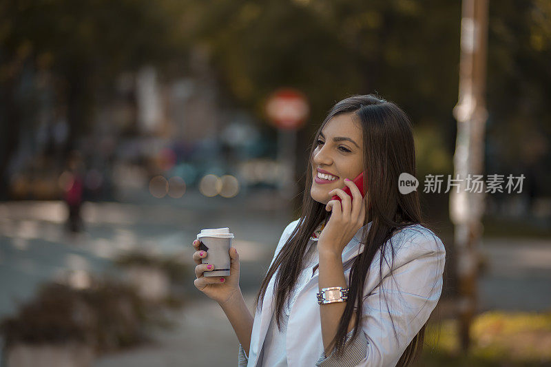 年轻的成年女性在街上用药片喝咖啡