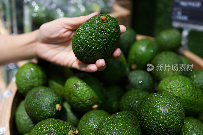 顾客在杂货店挑选牛油果