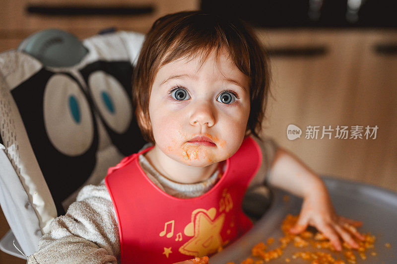 一个凌乱的女婴在高椅子上喂自己的肖像。