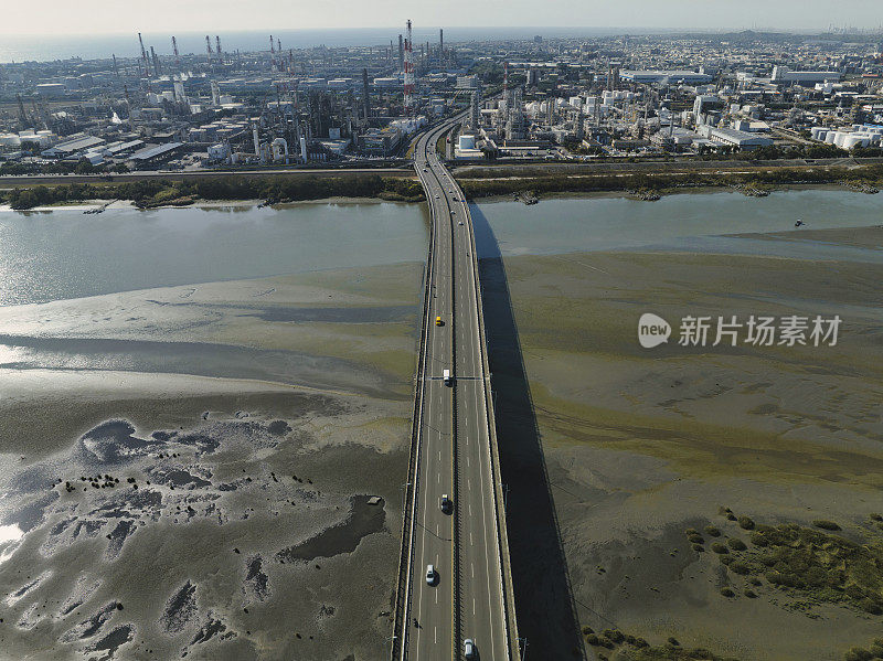 汽车在高速公路路口行驶的鸟瞰图。桥梁道路与绿色花园和树木相连接的建筑概念。