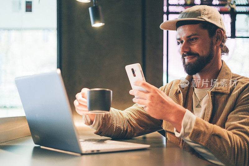 时髦的z世代白人男子在社交媒体上发布了一张他在咖啡馆工作的照片