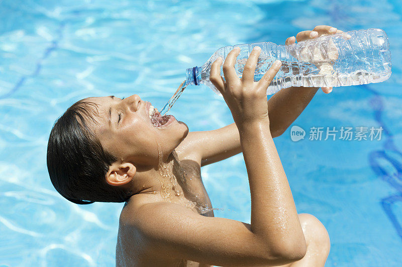 夏天，一个年轻人在游泳池里用塑料瓶喝水。由于热浪，有人从溅起的水瓶里喝水。饮用中暑或中暑的水