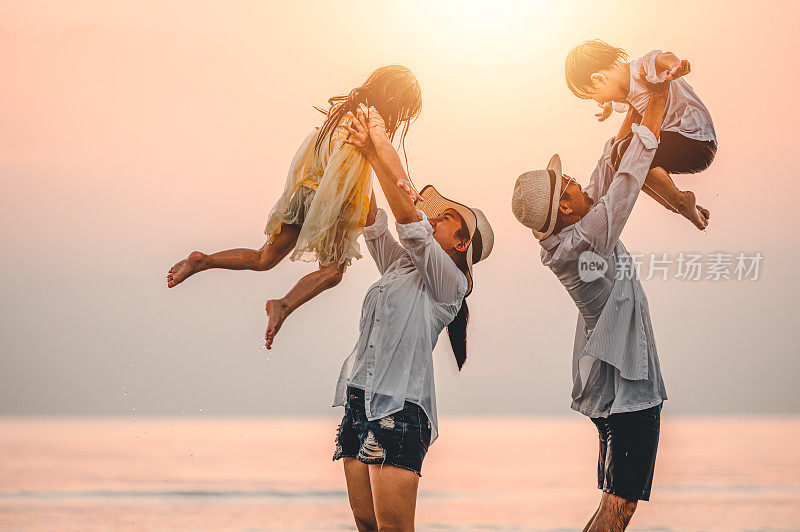 快乐的亚洲家庭在日落的海滩上玩海。全家人都喜欢带着孩子在海滩上玩耍。家庭、旅行、生活方式和假期。