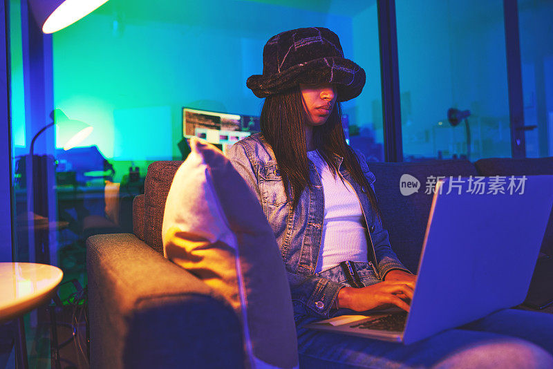 程序员、黑客和一个女人晚上在家里的霓虹灯下在笔记本电脑上打字，破解软件。网络安全、勒索软件网络钓鱼和女性程序员在电脑上编码，用恶意软件入侵数据库