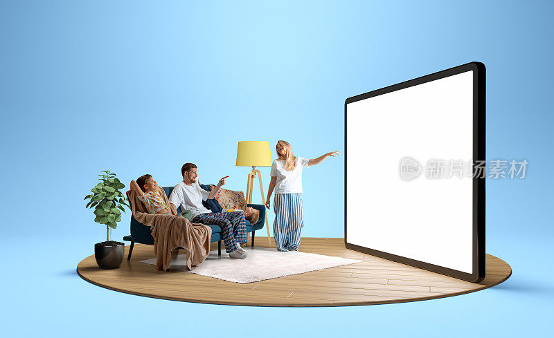 年轻的积极家庭穿着睡衣，男人，女人和孩子坐在沙发上，看着巨大的3D模型平板电脑与空屏幕