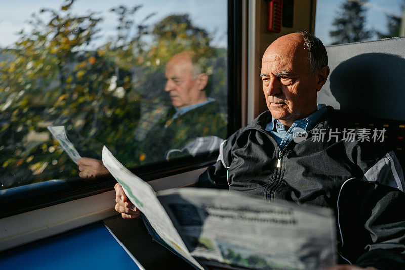 瑞士一位老人在火车上看报纸