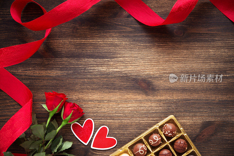 心形，巧克力松露和红玫瑰的木制背景