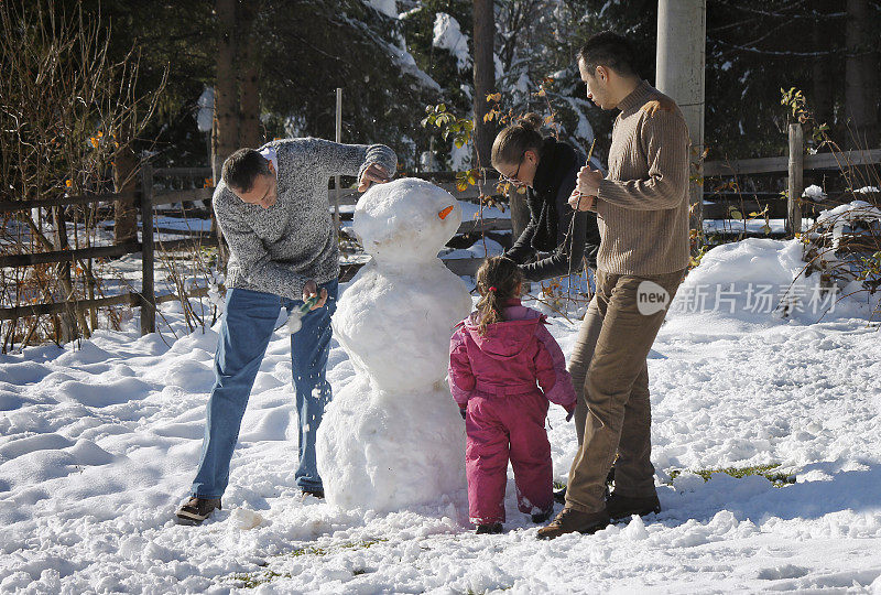 快乐的一家人堆雪人。