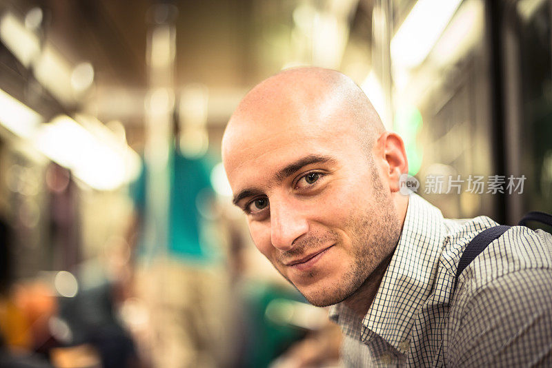 微笑的秃头男人在地铁上