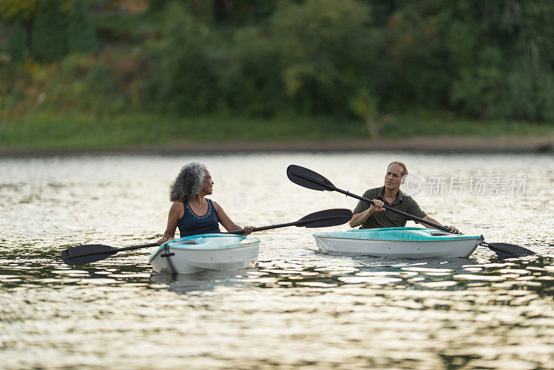 一对成熟的老夫妇在夏天一起划皮艇