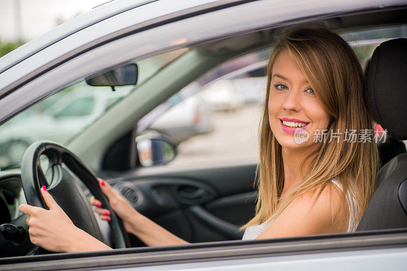女人在车里微笑着转动方向盘