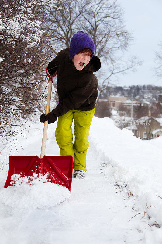 孩子在缤纷的冬天穿铲雪