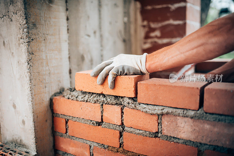 建筑工人在外墙上砌砖