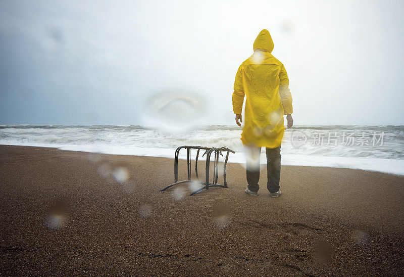 雨中站在海滩上的男人