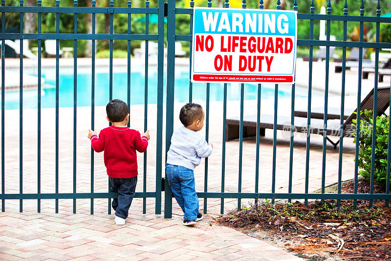 蹒跚学步的男孩试图进入一个未上锁的游泳池