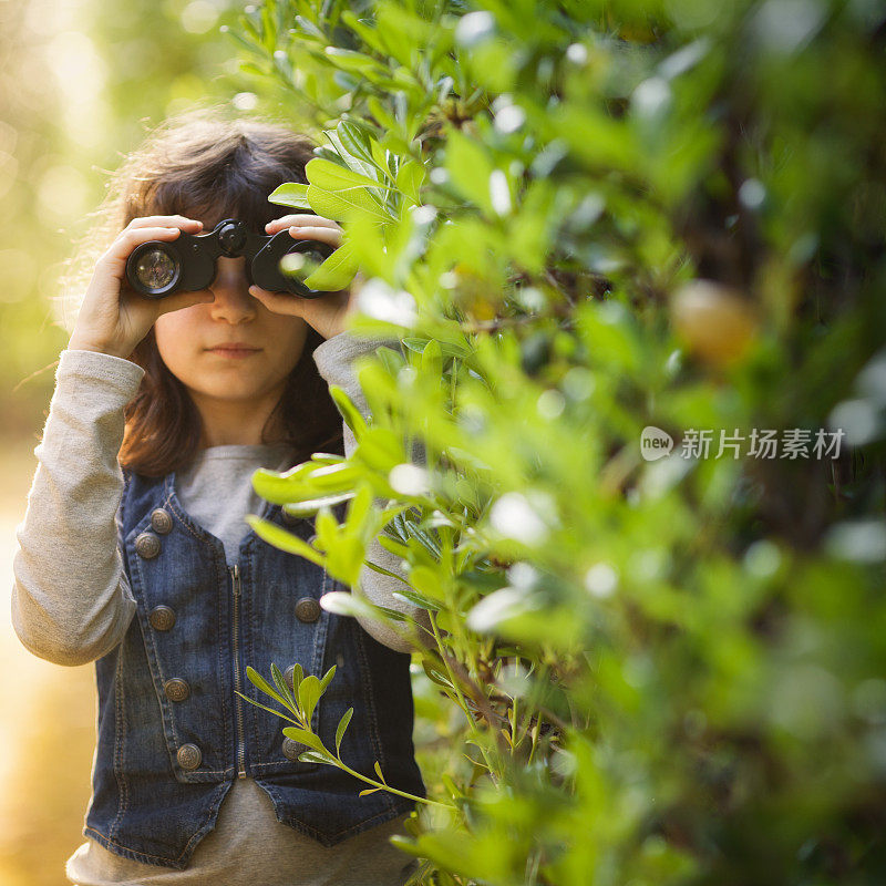 拿着双筒望远镜的年轻女孩