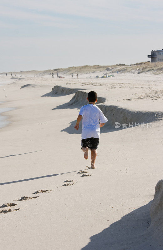 小男孩在海滩上跑步
