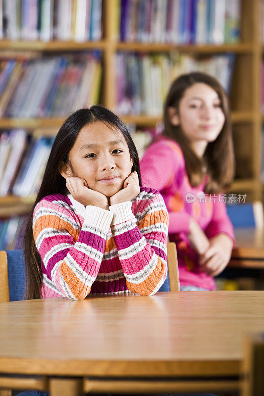 多种族女孩坐在学校图书馆里