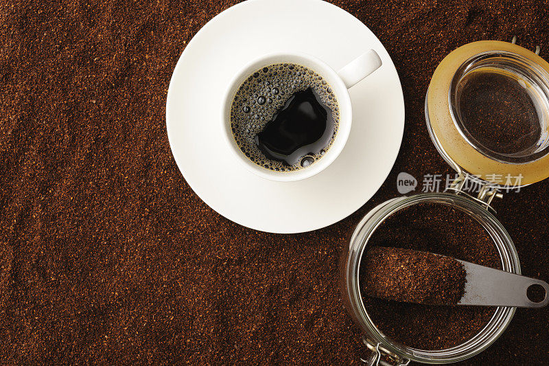 白咖啡杯里的黑咖啡和磨碎的咖啡豆