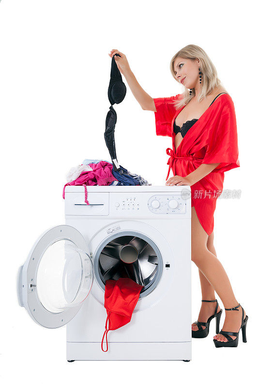 性感女人把胸罩从洗衣机上的衣服堆里拿出来