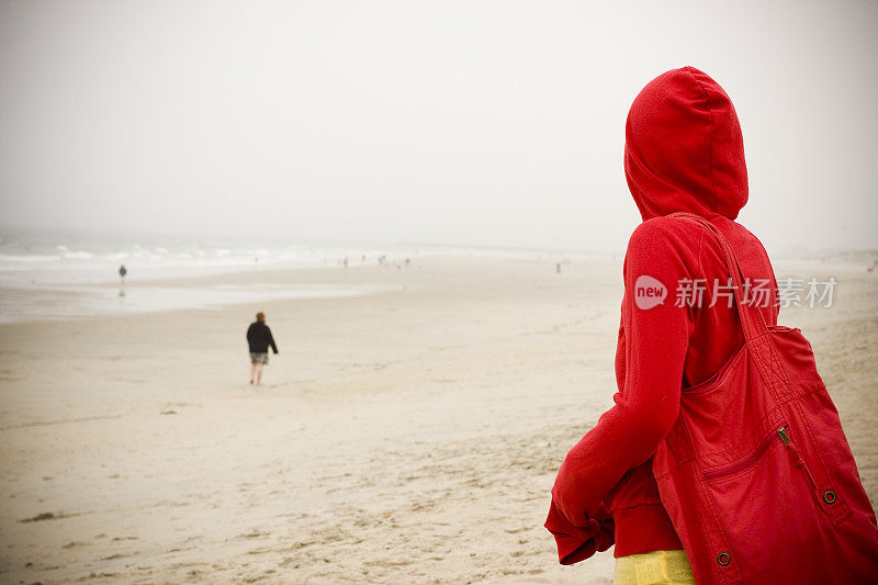 在下雨的海滩上迷路的女孩