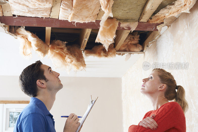 建筑商和客户检查屋顶损坏情况