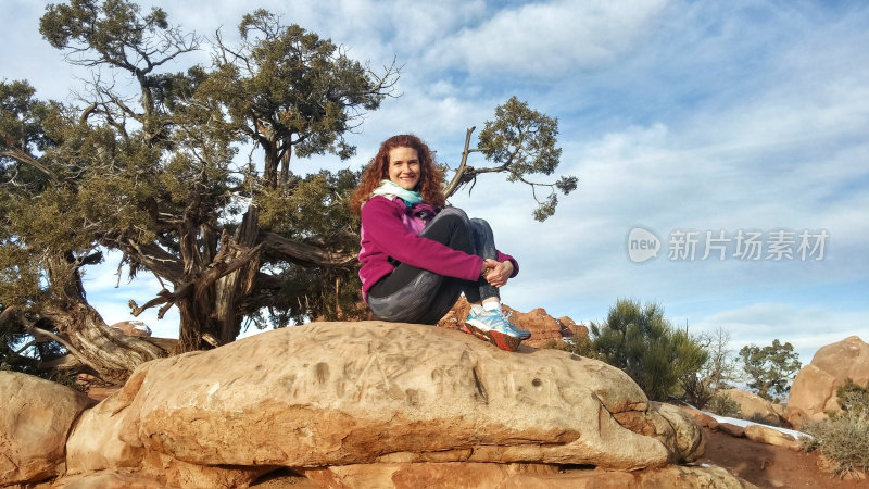 坐着的女性，杜松树，巨石，拱门国家公园