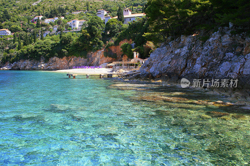 田园诗般的绿松石半透明的地中海海滩，杜布罗夫尼克住宅城市景观和海湾的蓝色水，亚得里亚海全景-达尔马提亚，克罗地亚