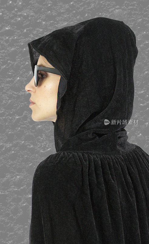 侧面寡妇女巫在黑色兜帽头部射击灰色背景