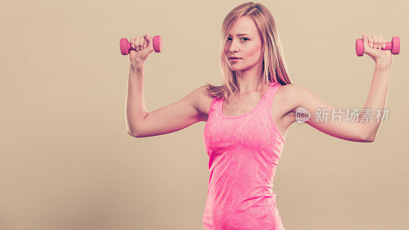 健身女性用哑铃锻炼。